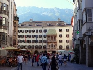 Historic center of Innsbruck with gold coloured roof and mountains behind